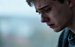 A young man with a distressed expression, symbolizing struggles with body image and eating disorders