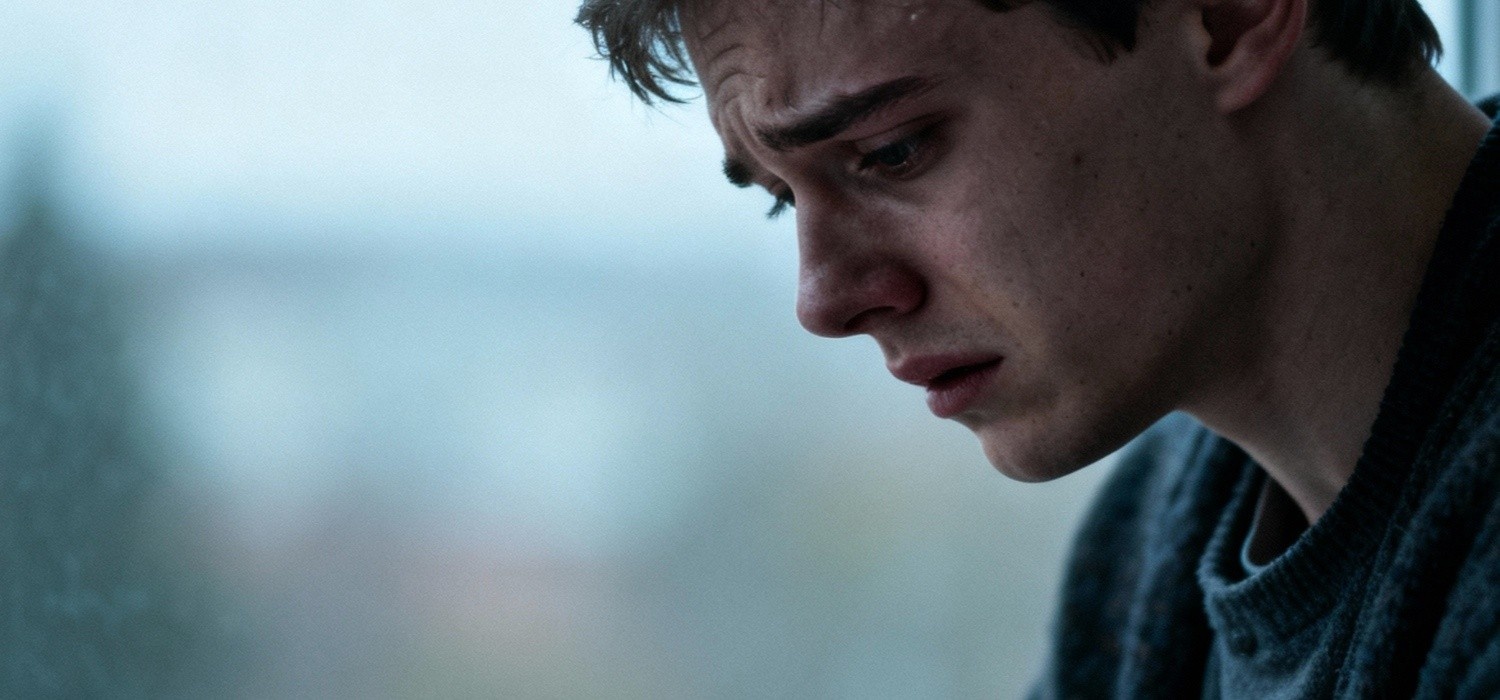 A young man with a distressed expression, symbolizing struggles with body image and eating disorders