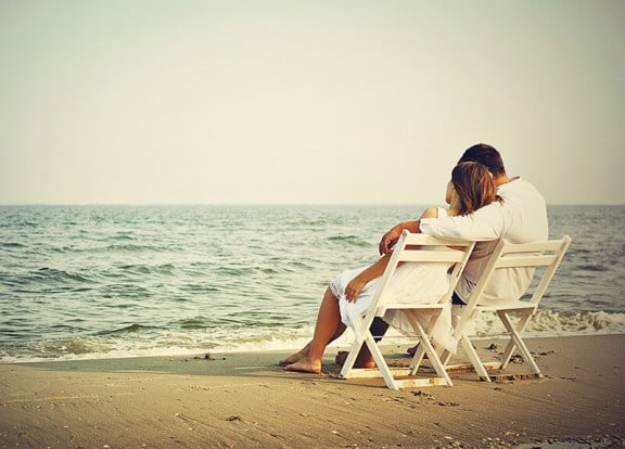 Couple sitting peacefully on chairs at beach watching the water