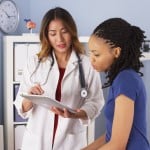 A doctor reviews test results with female patient