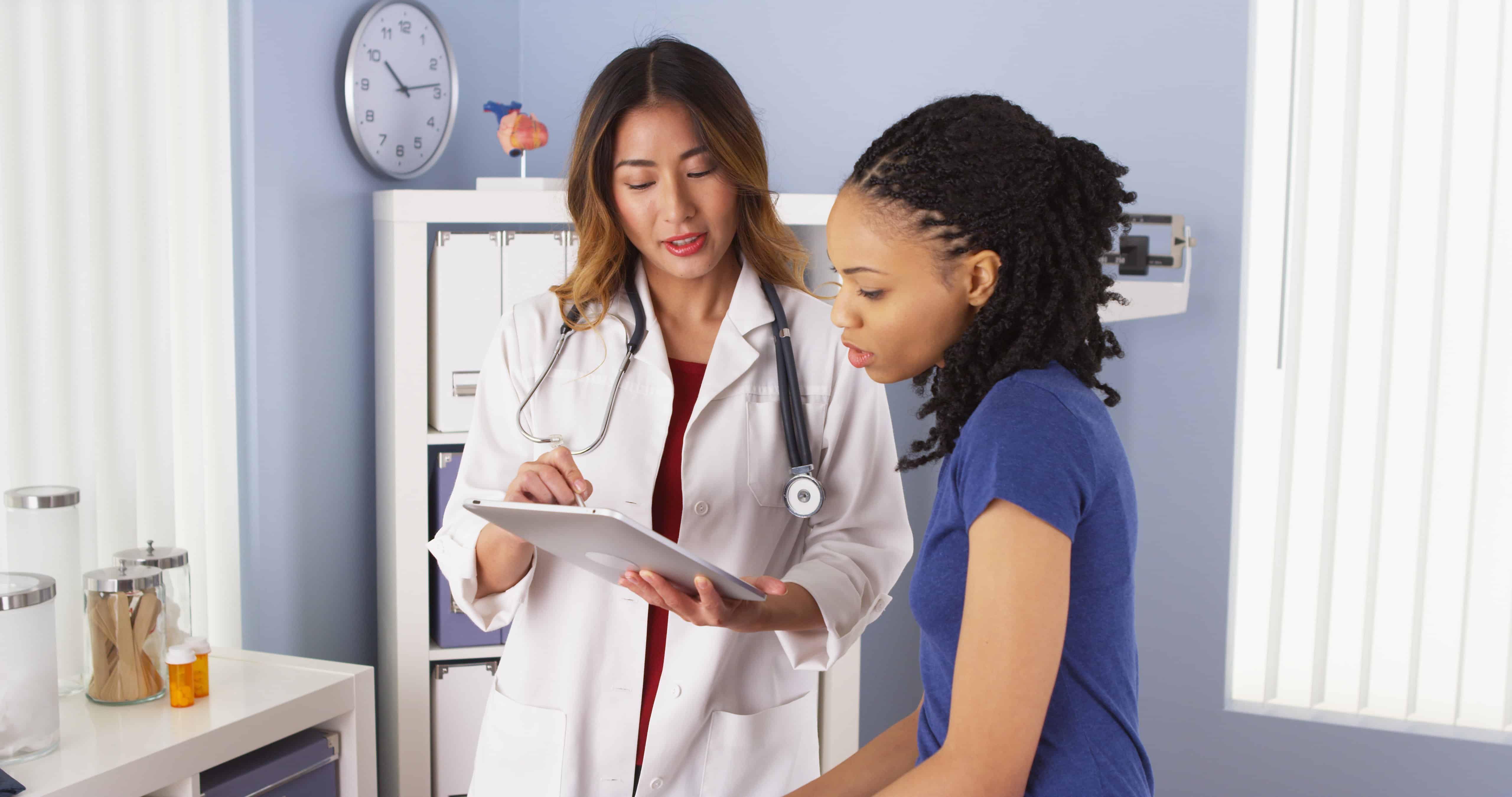 A doctor reviews test results with female patient