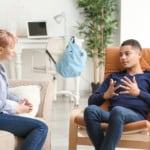 Female psychologist working with teenage boy in office