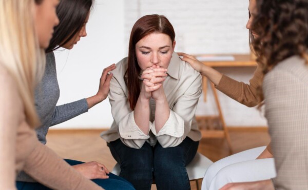 anxiety counseling girl receiving help at Total Life Counseling Dallas Anxious mother consumed by worry holds baby while staring blindly into the distance. Supportive husband looks upon his wife with concern.