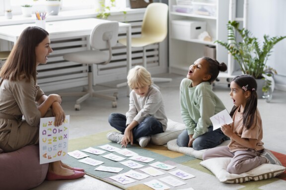 Female Play therapist helping a group of kids with mental health issues at Total Life Counseling Center Dallas Texas.