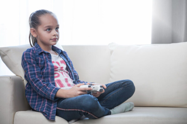 Girl playing video game on sofa Girl playing video game on sofa