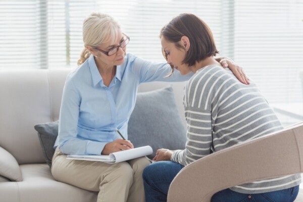 A therapist comforting a woman.