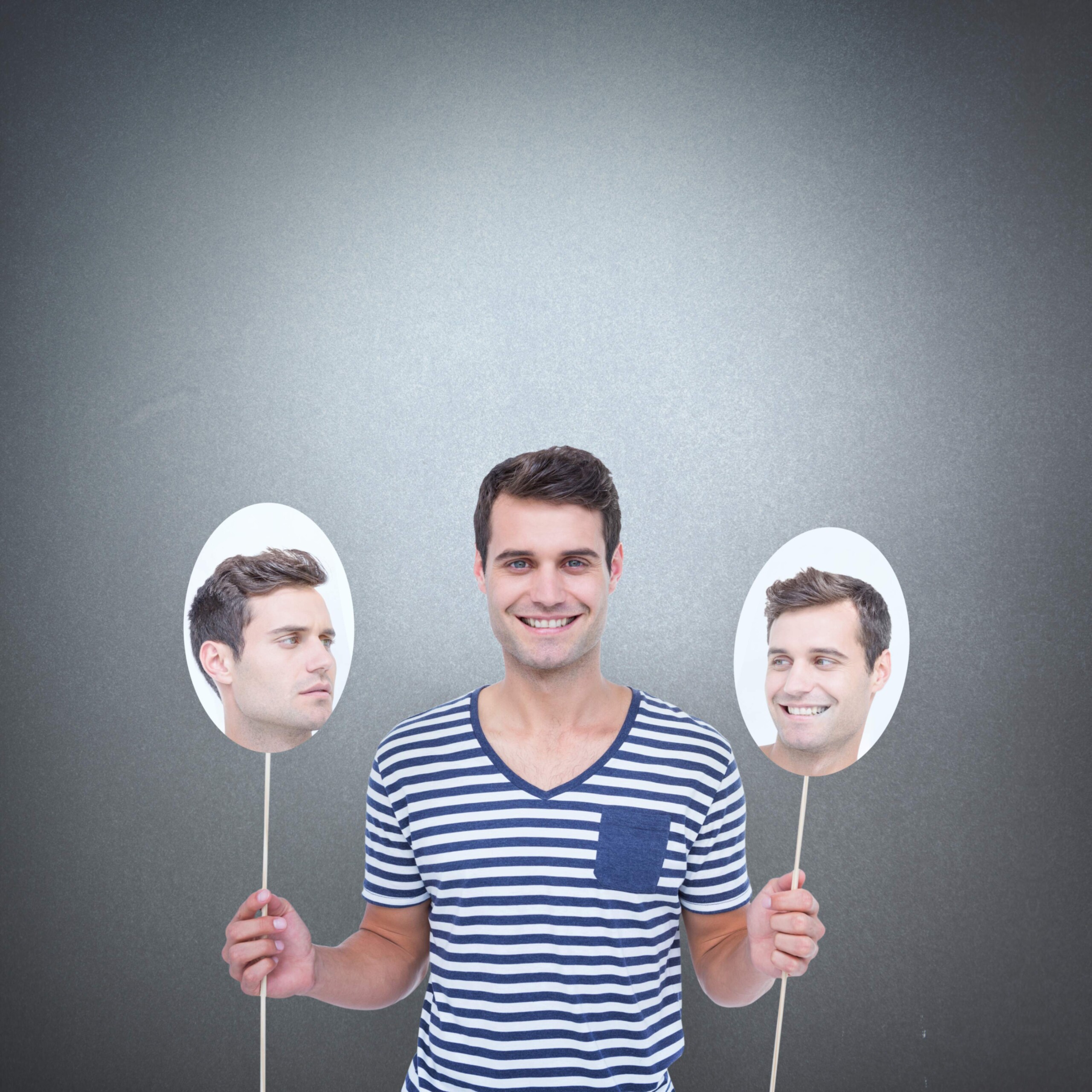 Man holding balloons with his face on them