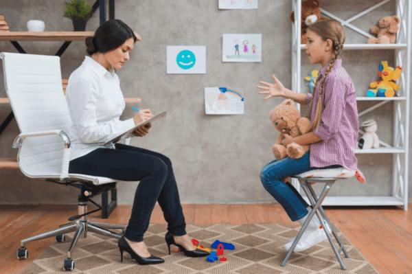 Female therapist taking notes during a play therapy session Female therapist taking notes during a play therapy session