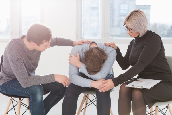 A man and a woman trying to console a trauma patient A man and a woman trying to console a trauma patient
