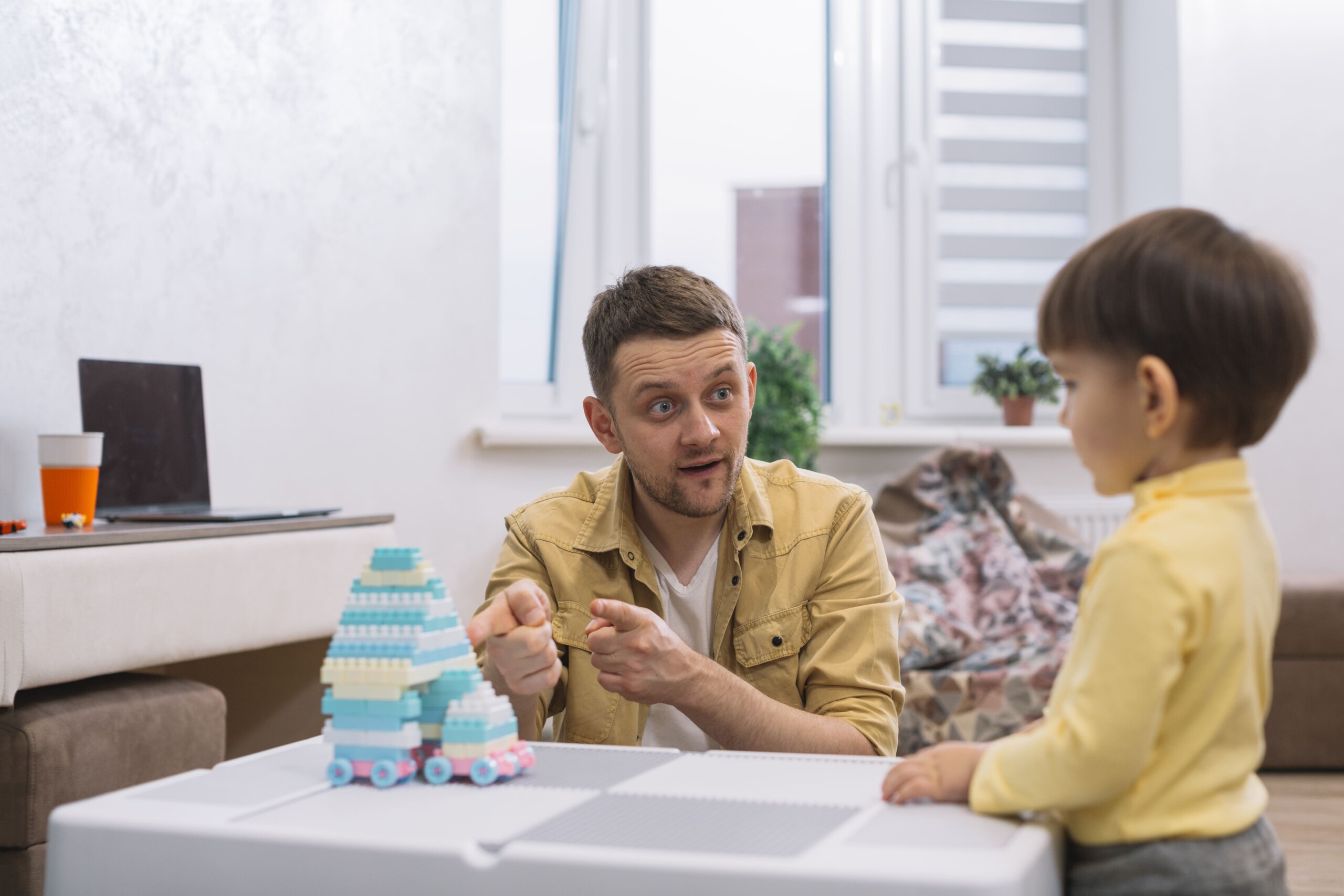 A man showing a play truck to kid