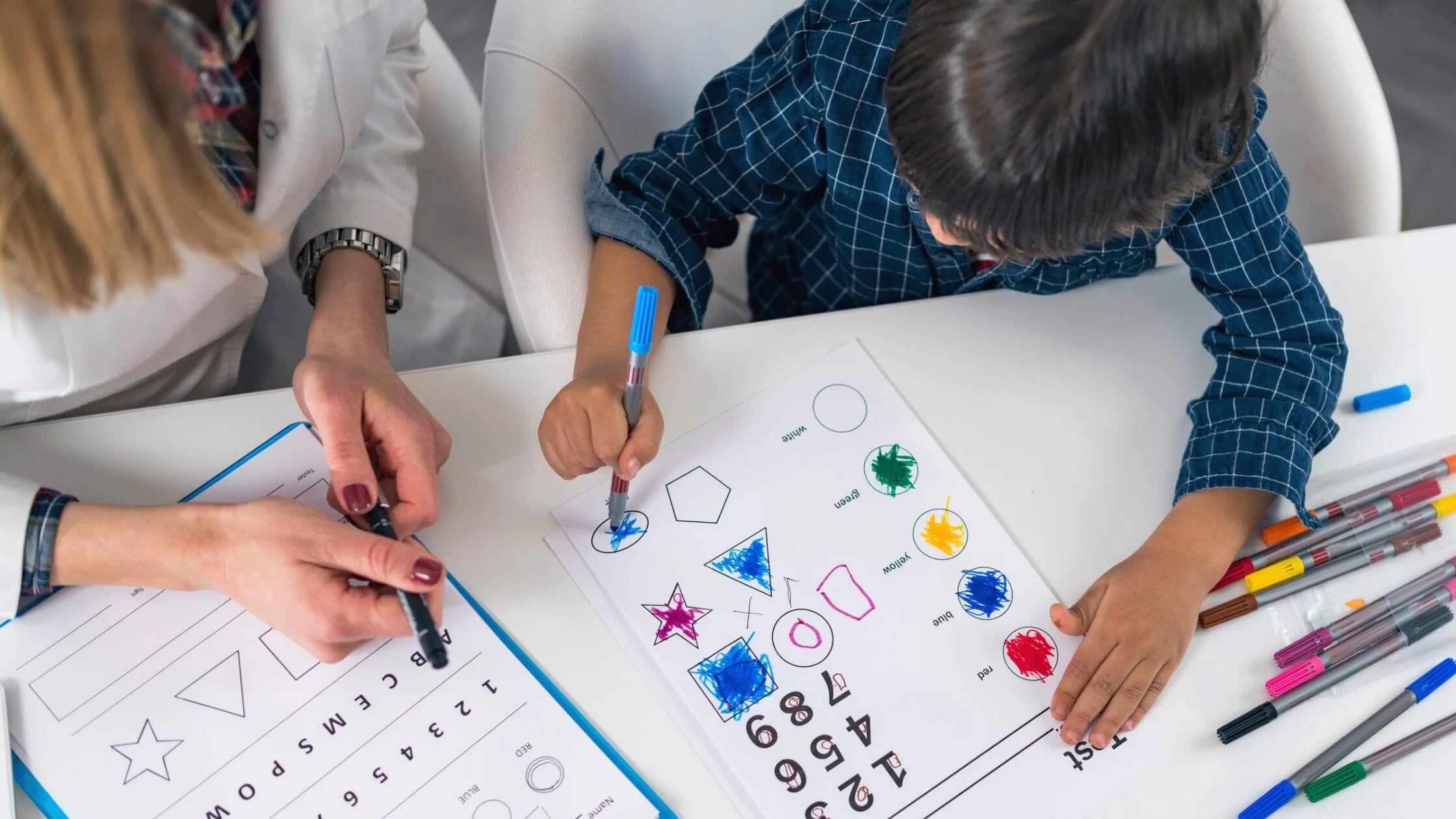 Child completing cognitive assessment with psychologist Child completing cognitive assessment with psychologist