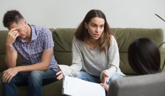 Couple in counseling session with therapist, showing conflict and frustration. Couple in counseling session with therapist, showing conflict and frustration.