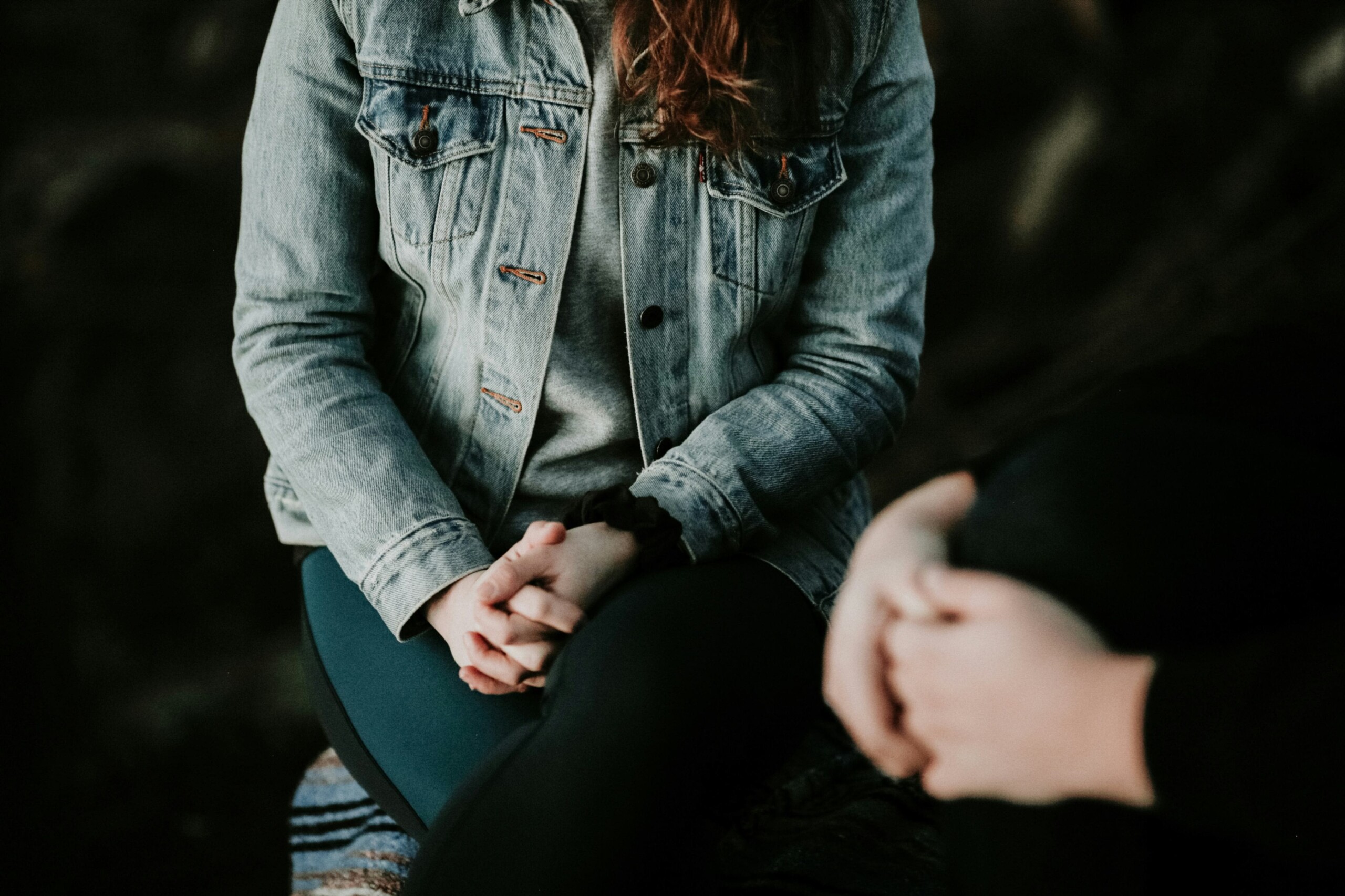 Person sitting with hands clasped during a counseling session