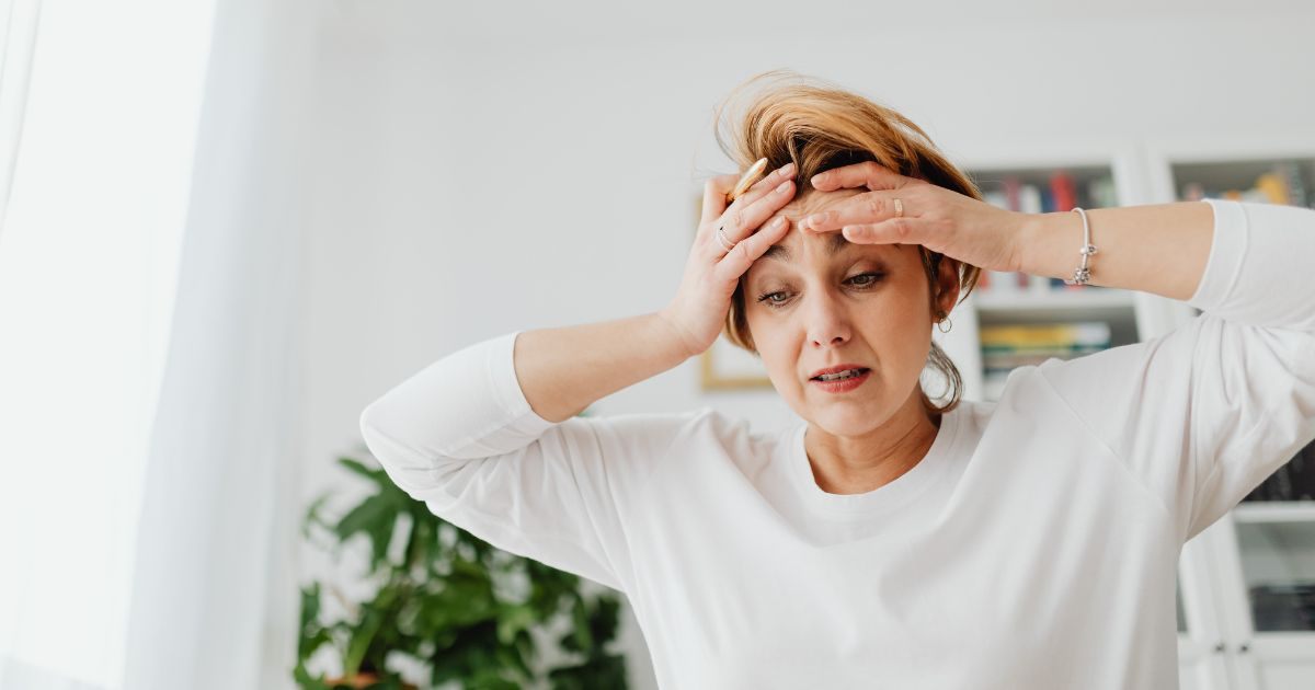 Woman holding her forehead in frustration Woman holding her forehead in frustration