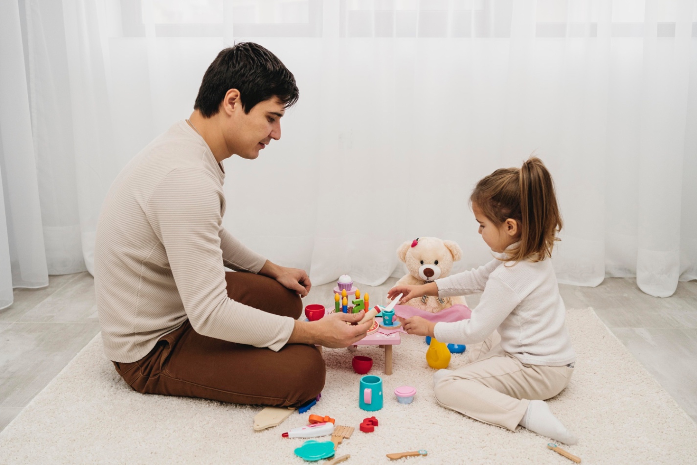 A parent sitting on the floor playing with a young child using toys in a calm home setting, showing quality family time and attentive interaction. - Total Life Counseling for Children, Teens, Adolescents and Adults in Orlando Winter Park Clermont Lake Mary and Central Florida A parent sitting on the floor playing with a young child using toys in a calm home setting, showing quality family time and attentive interaction.