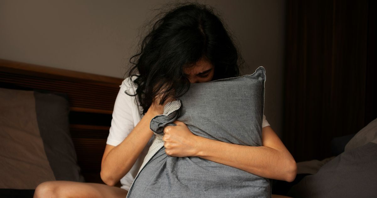 Sad woman holding a pillow and crying Sad woman holding a pillow and crying