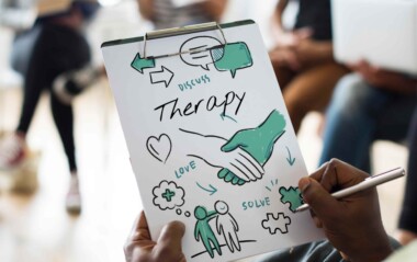 person drawing caricatures and writing therapy on a paper