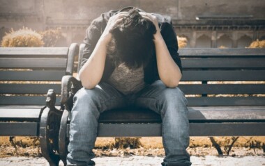 Sad man sitting on a park bench