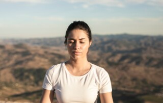 Woman meditating in the mountains