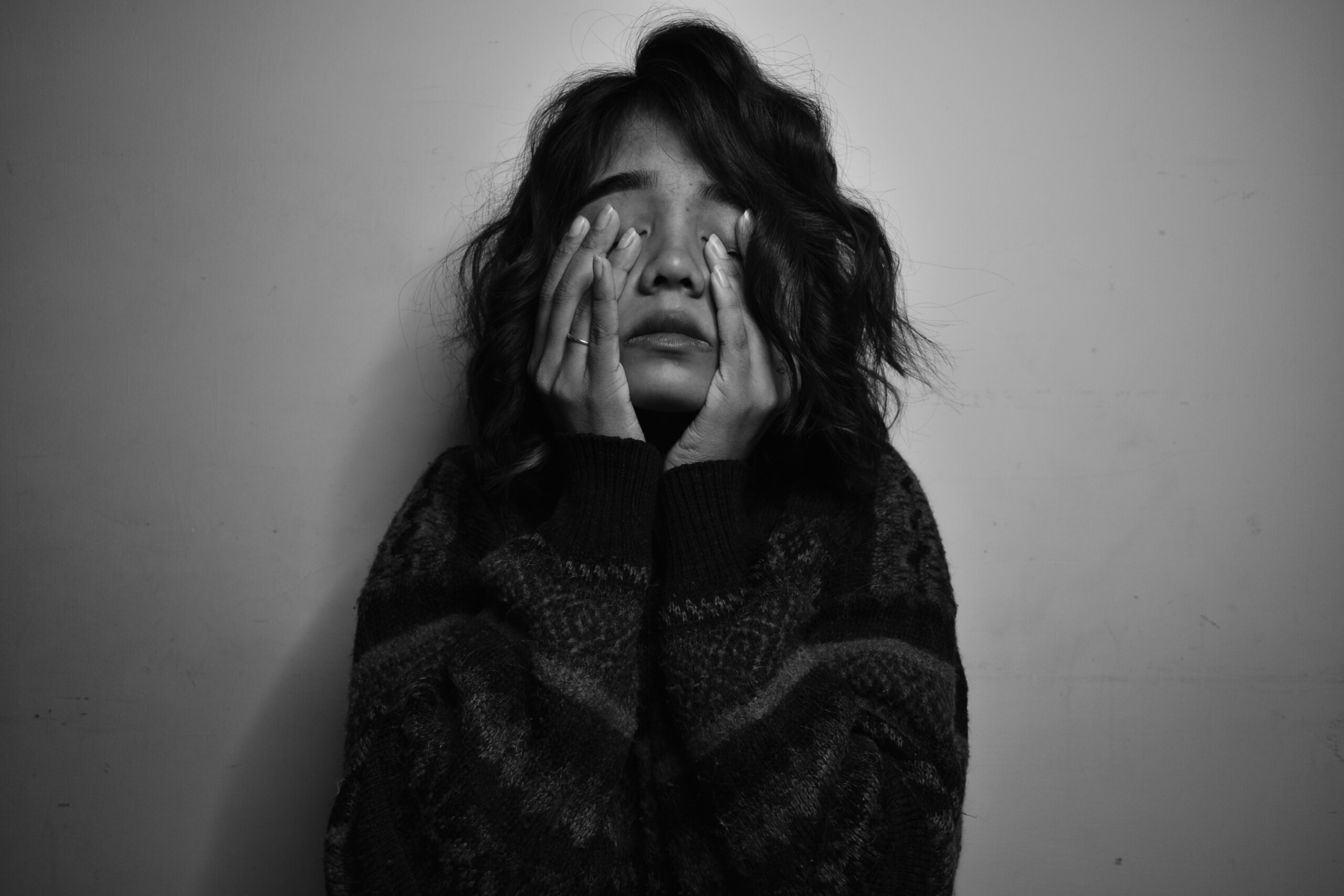 Stressed girl sitting with her face covered