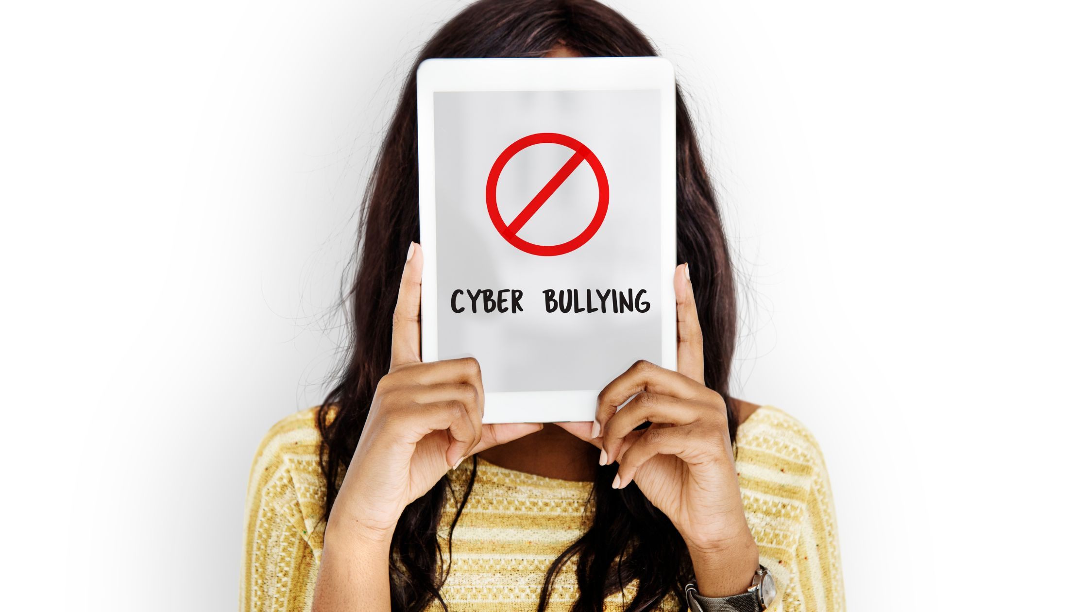 Person holding tablet with “Cyber Bullying” and stop icon