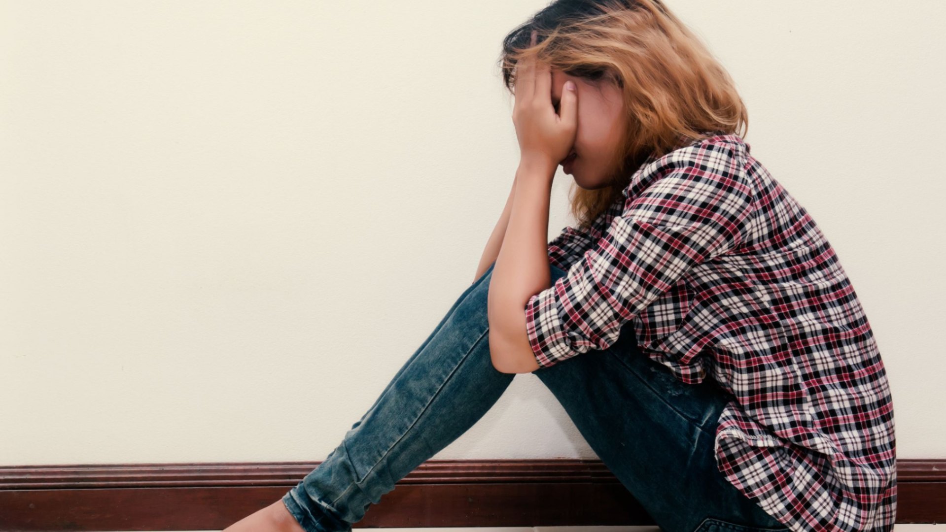 Sad teenager covering face with hands